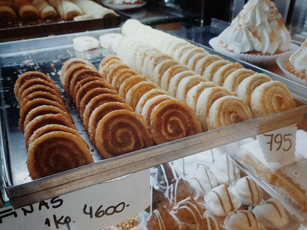 Arrollado with dulce de leche slices on display at a bakery.