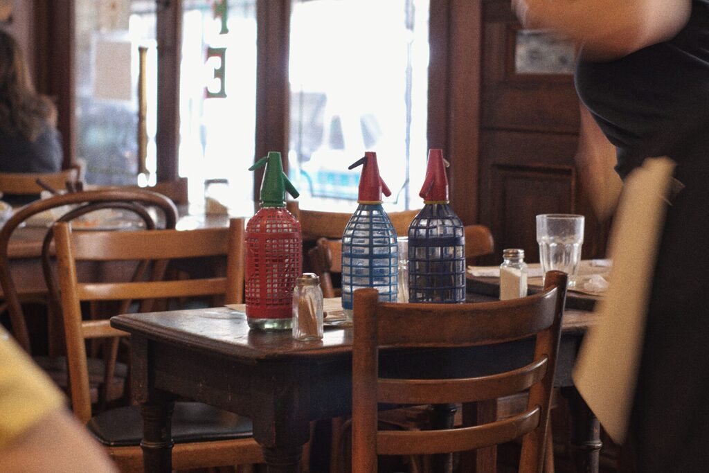 Wooden restaurant table with traditional sparkling water bottles.