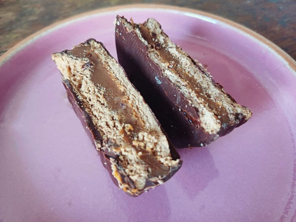 Cachafaz (left) and Havanna (right) chocolate alfajores served on a pink plate.